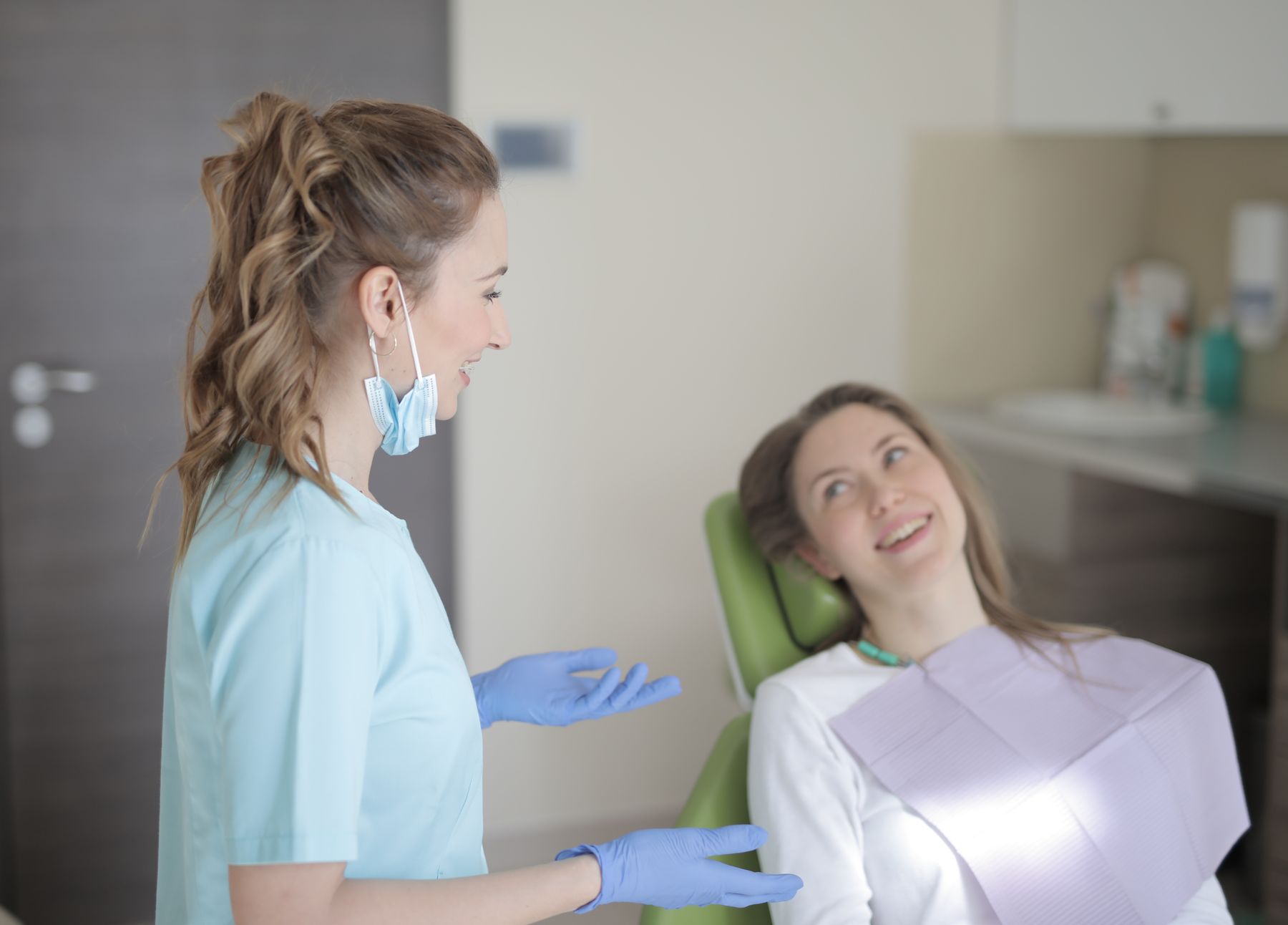 Dentista conversando com uma paciente em um consultório odontológico
